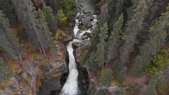 Waterfall Cascading Over Rocky Mountain Slope In Temperate Rainforest At Alaska, USA. - Aerial Tilt-