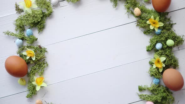 Colorful Decorative Easter Eggs Wreath on White Wooden Table Background