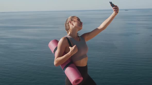 Girl in Sportswear Takes Selfie on Phone After Training, Shows Gesture of Peace