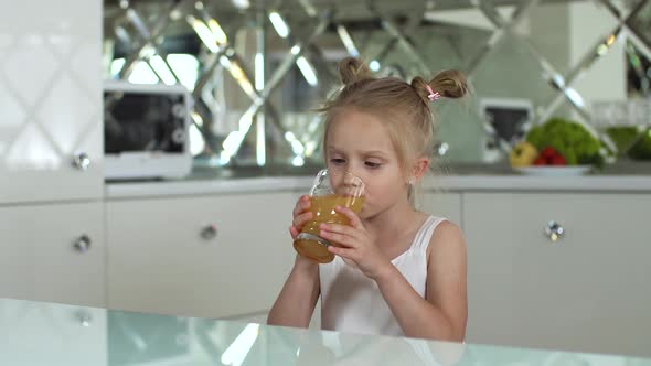 Child Nutrition. Little Girl Drinking Juice At Kitchen