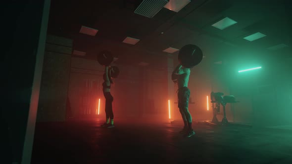 Male and Female Powerlifters are Training in Gym in Night Preparing to Competition