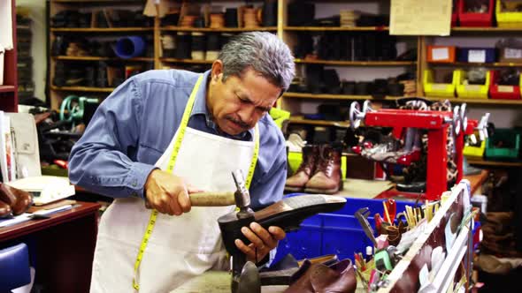 Cobbler making shoes with a hammer