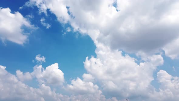 White puffy clouds and blue sky time-lapse with long second duration for background and graphics in