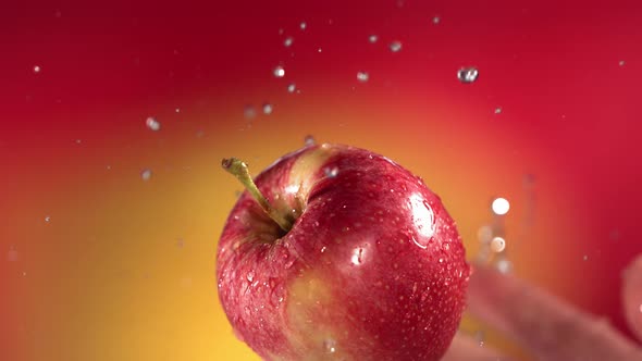 Flying of Red Apple in Red Yellow Background in Slow Motion