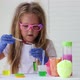 A little girl in pink glasses conducts experiments. - VideoHive Item for Sale