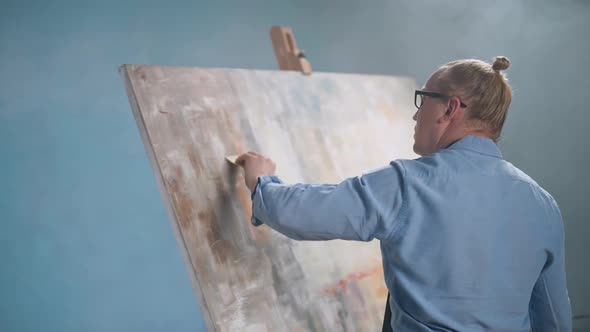 HANDHELD Creative Person in a Blue Shirt and Glasses at Work a Talented Adult Male Artist Draws an