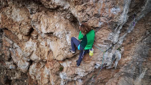 Slow Motion Aerial View Strong Female Rock Climber Climbs on Overhanging Cliff By Hard Route with