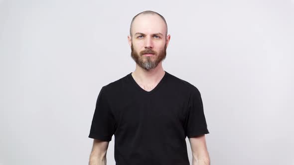 Portrait of calm bearded man looking at camera isolated over white background