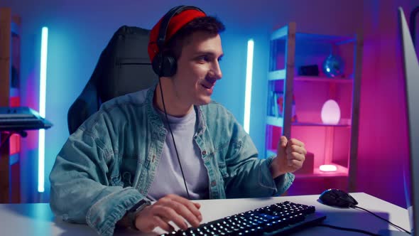 Young Hipster Man Playing Online Computer Video Game Colorful Lighting Broadcast Streaming Live Home