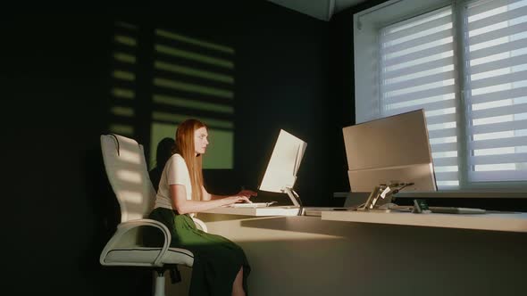 Woman Working on Computer in Empty Office