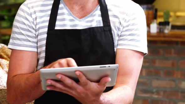Male waiter using digital tablet
