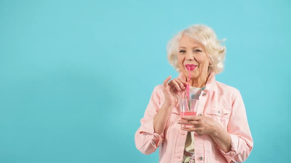Blonde Pretty Senior Lady in Stylish Clothes Enjoying Drink