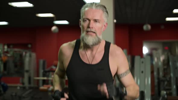 Running gray-haired man in the gym