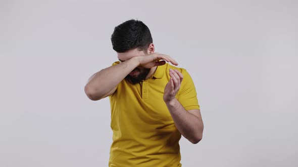 Young Man Cannot Believe His Eyes Rubs It and Peers More Closely at Camera on White Studio