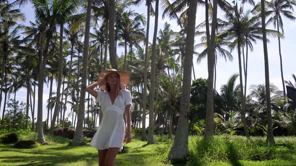 Cheerful Girl Having a Relaxing Walk Among the Palms