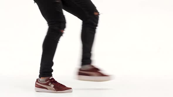 Man Is Dancing Breakdance on the White Background in Simple Grey T-shirt and Grey Jeans. Slow Motion