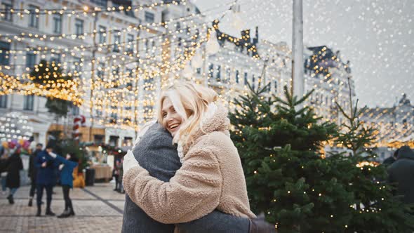 Senior Man and Woman Surprisingly Meeting During Walk on Christmas City Square and Hugging Enjoying