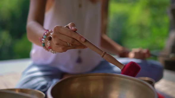 Superslowmotion Shot of a Woman Master of Asian Sacred Medicine Performs Tibetan Bowls Healing