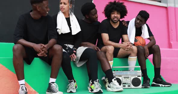 Group of young african people listening music from vintage boombox stereo outdoor