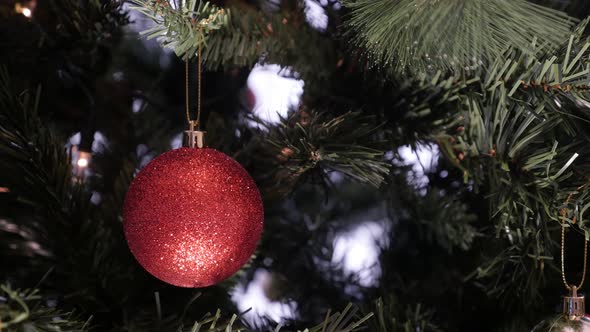 Close-up of glittering surface ornament on Christmas tree 4K 2160p 30fps UltraHD footage - Red  colo