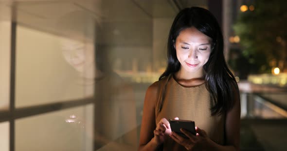 Woman looking at mobile phone in city 