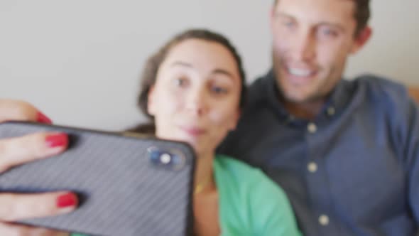 A young happy caucasian couple in love smiling and taking selfie