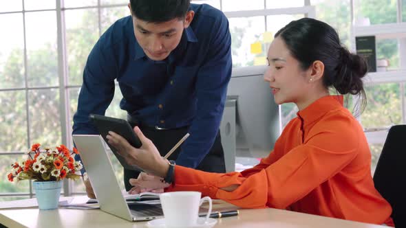 Two Business People Talk Project Strategy at Office