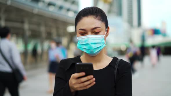 business woman using smartphone and wearing medical mask for protection from coronavirus