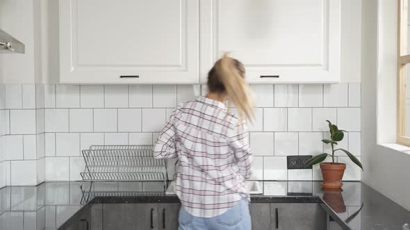 Beautiful Woman Washing Dishes at Kitchen Sink While Doing Cleaning at Home at Weekends