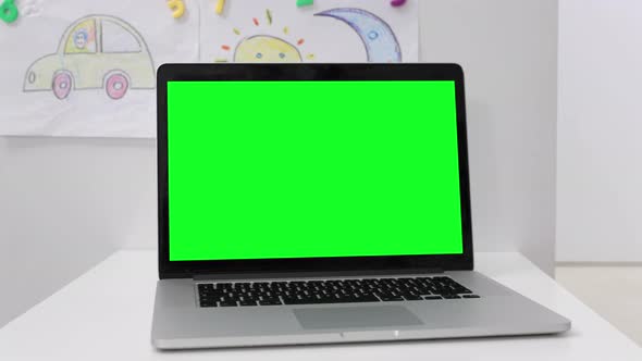 a Laptop with a Green Screen in Kid's Room