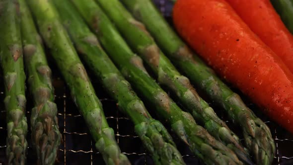 Cooking carrots and asparagus in charcoal grill