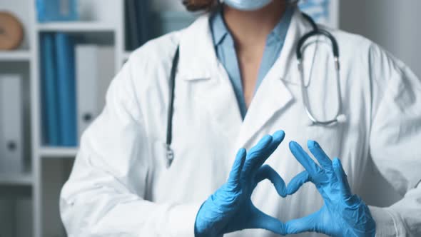 The Heart Sign Is Shown By The Medic. Gesture Heart Doctor Folded Shows Hands In Gloves