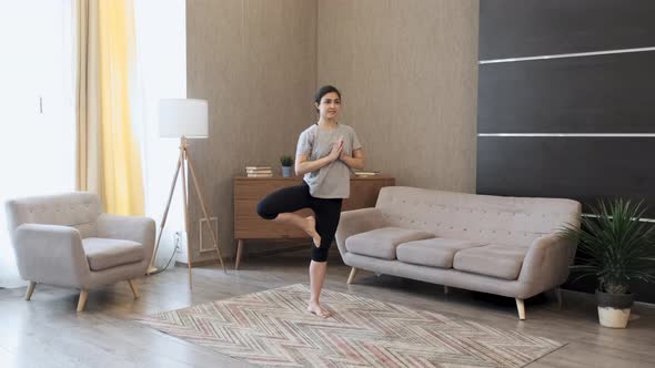 Young Indian Woman Meditating Standing on Carpet and hand Namaste, Doing balance