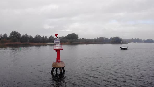 Pleasure yacht sailing without sails on a Dutch fairway on the right side of the navigation tower. D