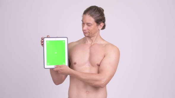 Happy Muscular Shirtless Man Showing Digital Tablet