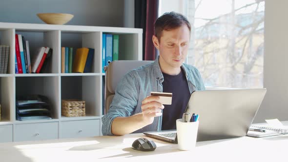 Young male entrepreneur works at home office at the computer.