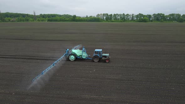 Powerful Agricultural Tractor Apply Mineral and Nitrogen Fertilizer on Ground at Field