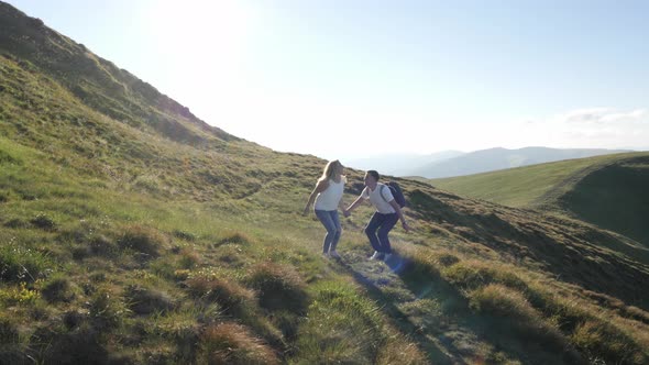 Couple jumping on a sunny hill