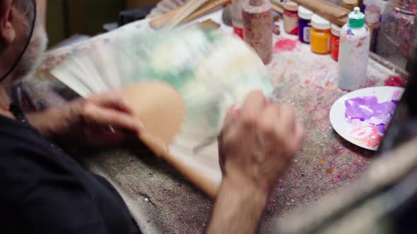 artist painting on handmade waver in studio