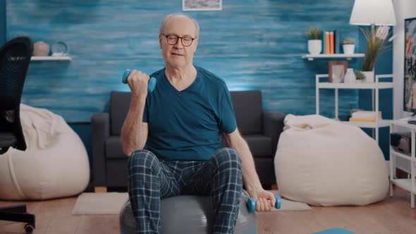 Portrait of Senior Man Sitting on Fitness Toning Ball