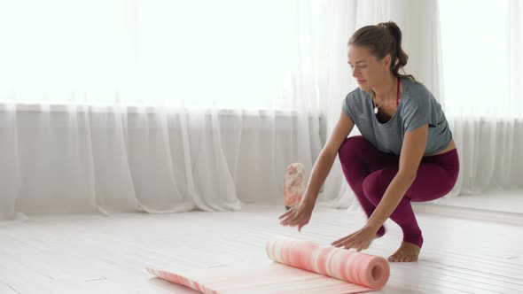 Woman Rolling Up Mat at Yoga Studio or Gym 65