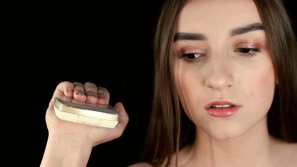 The Girl Is a Model of a Make-up Salon, Holds a Powder Box with a Mirror in Her Hand and Closes It