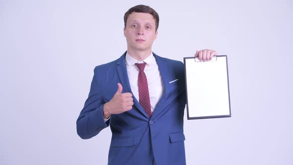 Happy Young Businessman Holding Clipboard and Giving Thumbs Up