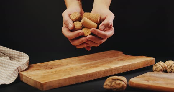 Woman's Hands Drop Wine Corks on Old Cutting Board