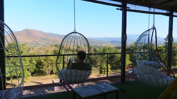 Unusual Cafe with Hanging Chairs and Views of Green Mountains and Blue Sky