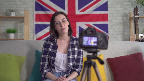 Portrait Young Woman Blogger in Shirt on the Background Flag of Great Britain Recording Video
