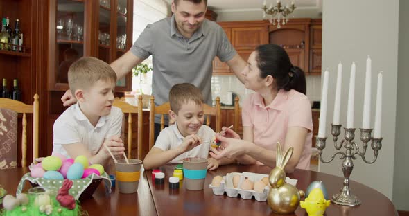 the Father Hugs His Wife and Two Children From Behind