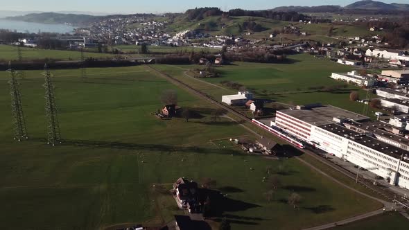 Aerial panning shot of passing swiss train and beautiful landscape shot in background,Hills,green f