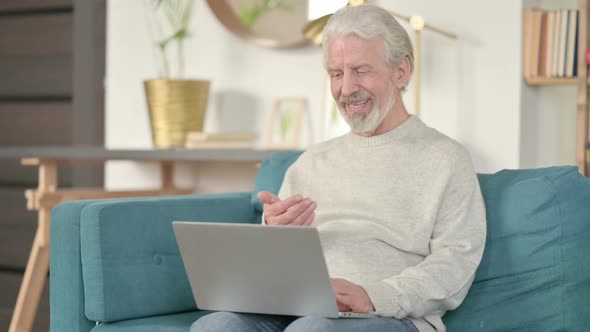 Online Video Call on Laptop By Old Man on Sofa