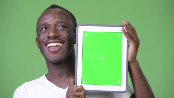 Young Happy African Man Thinking While Showing Digital Tablet